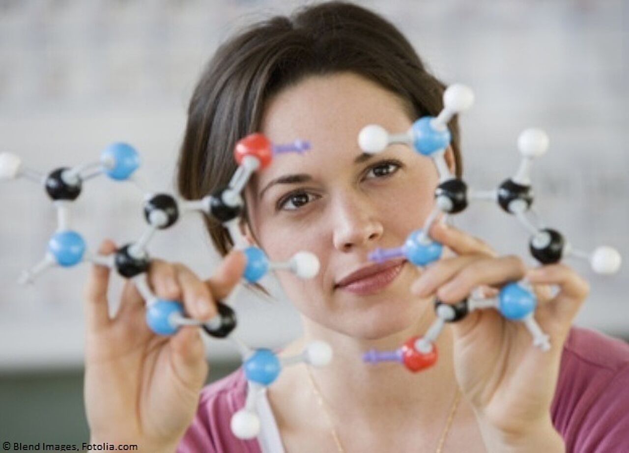 Frau hält Modell eines Moleküls