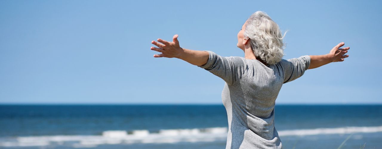 Grauhaarige Frau am Meer